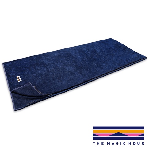 深藍色絨面睡袋毯，呈現信封式設計，部分拉鍊開口，左上角有白色標籤。