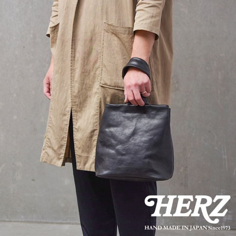 職人手作黑色皮革Organ單柄手提包，方形包身，簡約設計，搭配圓形提把。