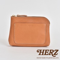 職人手作的淺棕色皮革小物收納包，配有黃銅拉鍊和一個前方貼袋，袋身有精緻的縫線裝飾。