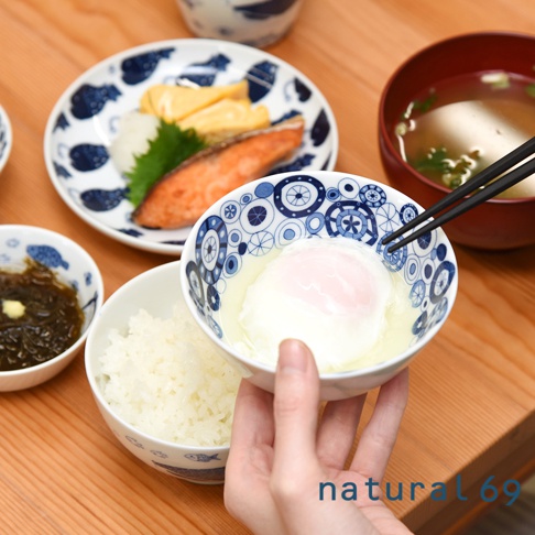 一個盛有水煮蛋和湯汁的白色陶瓷小碗，碗身飾有藍色和白色的循環圖案。