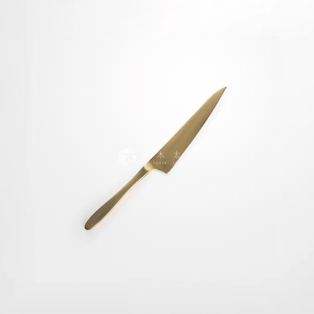 一支金色的水果刀，刀身光滑，刀柄呈弧形，頂端有品牌標誌。