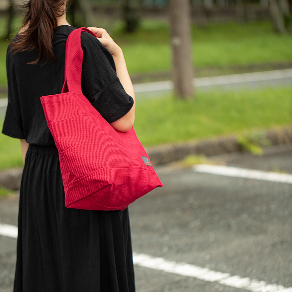 紅色三河木綿刺子織大容量托特包，材質為棉，具有細緻的織紋，包款設計簡約，適合日常攜帶。