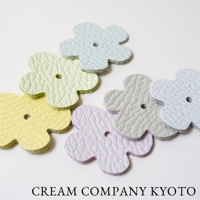 六個皮革製成、花朵形狀的裝飾配件，分別為淡黃色、淺綠色、淡紫色、淺灰色及淺藍色，每個配件中央皆有一個小圓孔。