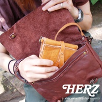 職人手作復古皮革郵差包，呈現深棕色水洗加工質感，包包內側為淺棕色皮革。