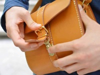 職人手作皮革皮扣單肩包 (CP-38)，採用天然棕色皮革製成，配有復古黃銅色金屬皮扣和調節帶，手工縫線細緻。