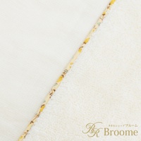 今治純棉浴袍，象牙白，一面為素色棉質，另一面為絨毛棉質，兩者間以印有黃色小花圖案的織帶拼接。