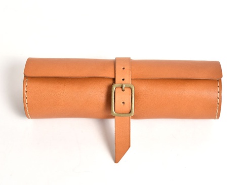 職人手作皮革捲捲收納筆袋 (KP-100)，原色皮革，附有古銅色針扣皮帶固定，邊緣縫線清晰。