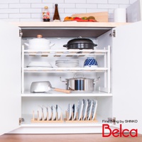 白色伸縮槽下雙層L腳收納架，架上層有白色鍋具、黑色鍋具、白色盤子、藍白花紋碗，中層有銀色鍋具，下層有兩個木製盤架，分別放置多個白色和藍白花紋的盤子。