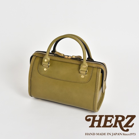 橄欖綠皮革迷你波士頓包，配有金色拉鍊、雙提把和品牌標誌。