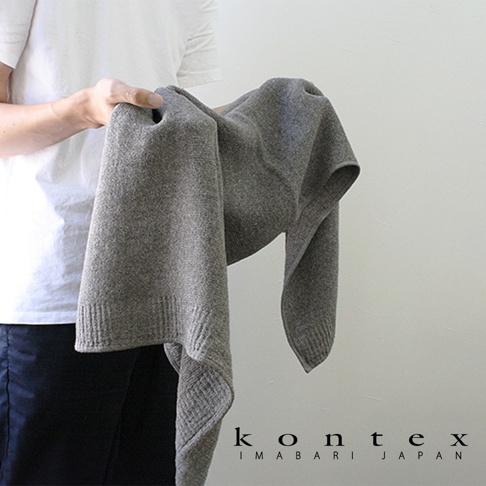 一條淺灰色純棉針織毛巾，展示其柔軟的質地和精緻的編織細節，邊緣帶有羅紋設計。