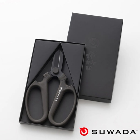 黑色啞光質感的高級日本SUWADA園藝剪刀放置於黑色禮盒中，剪刀本體呈現簡約工業風，握柄刻有品牌名稱，配有黑色精緻外盒，整體的拍攝視角為由上往下的俯視圖。