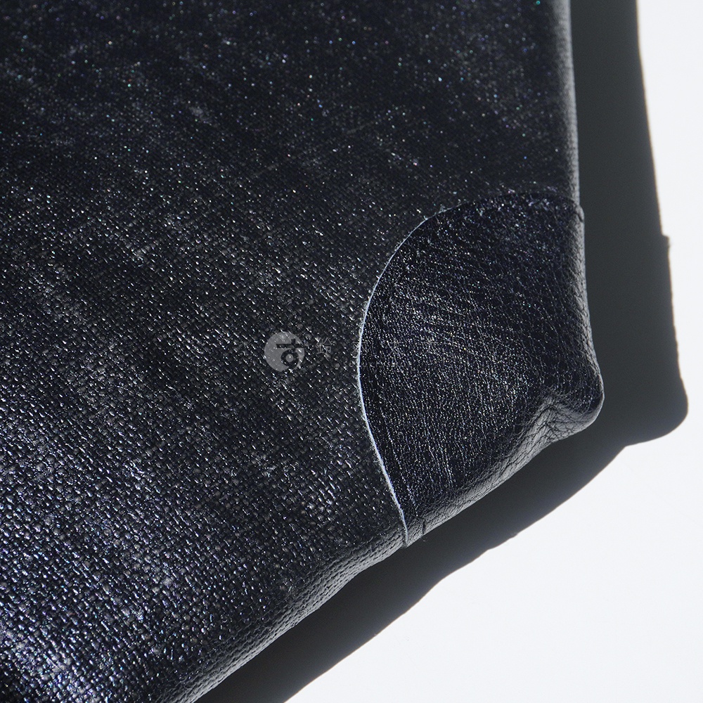 BAN INOUE 釉面亞麻布三用托特包局部特寫，展示包包一角的縫線細節與一個標示為 10 的圓形標誌。