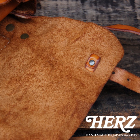 復古棕色皮革水洗加工，細膩絨面，帶有金屬釦和皮革束帶，展現職人手作質感。