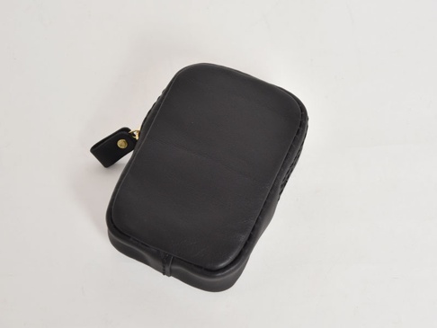 黑色皮革菸盒收納包，方形設計，附有拉鍊開合及皮革拉環，材質柔軟，質感佳。