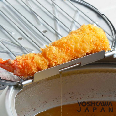 銀色不鏽鋼炸網上放著一條炸至金黃色的天婦羅炸蝦，炸網架在油鍋上方，有油滴從炸蝦上滴落。