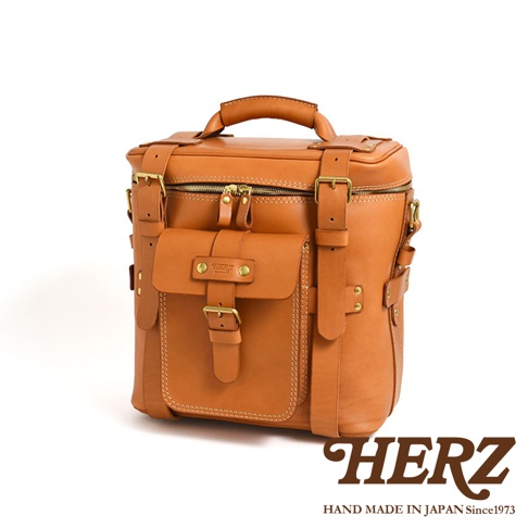 棕褐色皮革大型三用旅行後背包，設計簡約，配有頂部提把、可調節肩帶、多個扣環和一個前置翻蓋口袋。