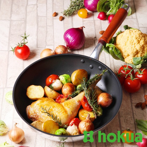 一個30公分輕量炒鍋，內含烤雞腿、馬鈴薯塊、小番茄、抱子甘藍、洋蔥和迷迭香，鍋柄為天然木材質，鍋身為銀色金屬。