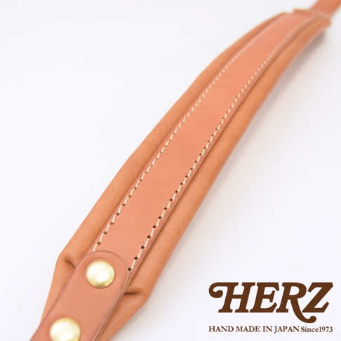 職人手作皮革加厚減壓肩背帶，採用棕褐色皮革，內襯柔軟材質，車縫線整齊，設有兩個金色鉚釘，適合搭配各種包款。