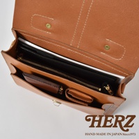 職人手作皮革三用單扣商務後背包，內部展示，可見咖啡色皮革、拉鍊夾層、皮夾及平板電腦，設計簡潔實用。