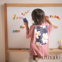 木製多功能兒童繪畫白板，附有磁性字母與數字，一名兒童正使用藍色擦子擦拭白板，白板上有綠色線條塗鴉。