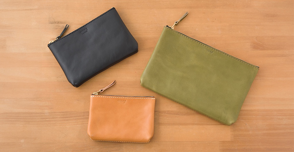 職人手作皮革長方形拉鍊收納包，共展出黑色、綠色、橘棕色三款，皆為真皮材質，配有金色拉鍊及皮革拉環，簡約大方。