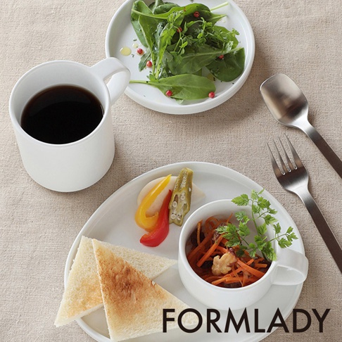 白色陶瓷馬克杯，裝有深色飲品，旁邊為裝有沙拉、三明治、醃漬物及燉菜的餐盤，搭配金屬湯匙和叉子。