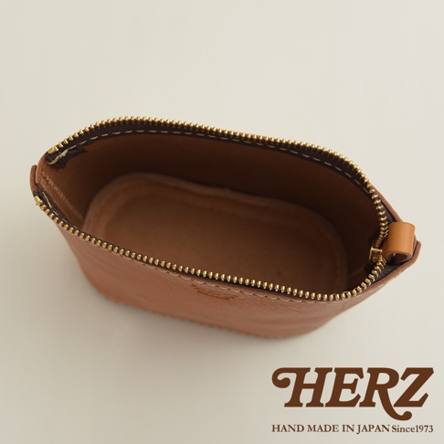 職人手作皮革三角收納包，淺棕色，拉鍊開合，內部空間展示。