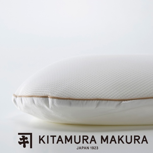 一個白色網狀材質的豌豆枕，側面有米色滾邊，整體為圓潤的曲線。