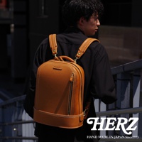 棕色皮革立體商務後背包，簡約設計，配有拉鍊開口和品牌標誌。