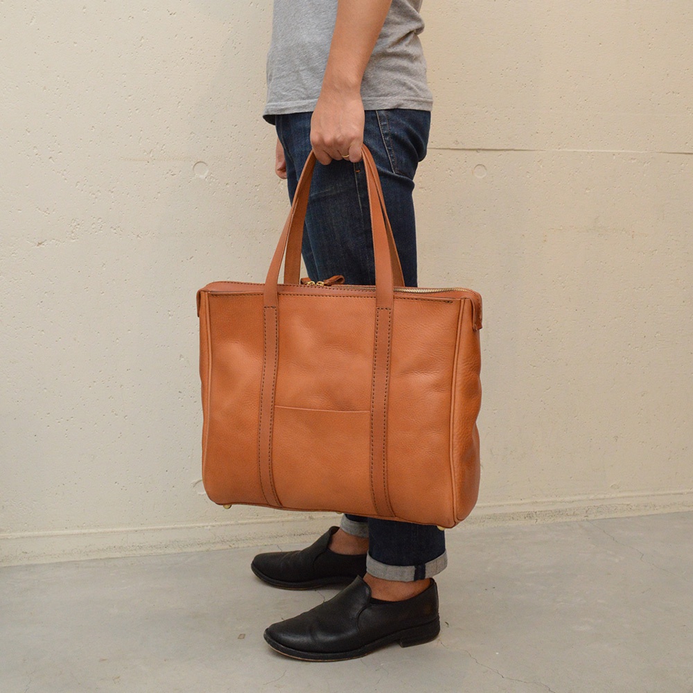 職人手作皮革Organ肩背拉鍊托特包 G-58，採用棕褐色皮革製成，側面可見拉鍊開合與提把，正面有一平整的置物袋，包款為方形結構，整體風格簡約。
