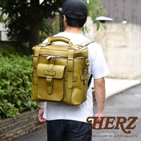 職人手作皮革大型三用旅行後背包，呈現橄欖綠色，採用厚實皮革製作，設計有頂部提把、雙側袋、前置翻蓋口袋及多處皮帶扣環，適合旅行攜帶。