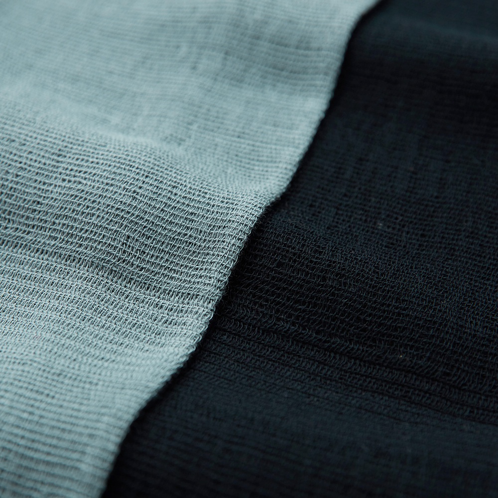 今治匹馬棉雙色圍巾，一邊為淺灰色，另一邊為深灰色，織紋細緻。