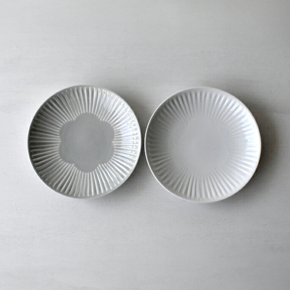 兩件式主食盤，一個為淺灰色，內有花瓣狀凹槽，另一個為白色，表面有放射狀線條凹紋，皆為陶瓷材質。