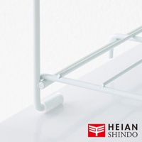 白色金屬網架結構，具有水平支撐條和垂直支架，底部有圓形腳墊，用於廚房收納。