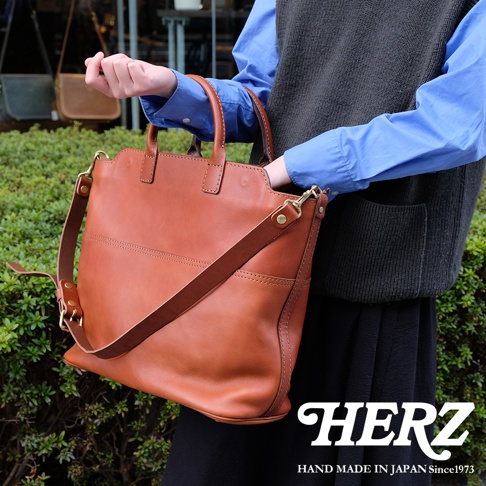 棕色皮革製成的大容量兩用托特包，配有可拆卸肩帶，簡約設計，質感自然，適合日常攜帶。