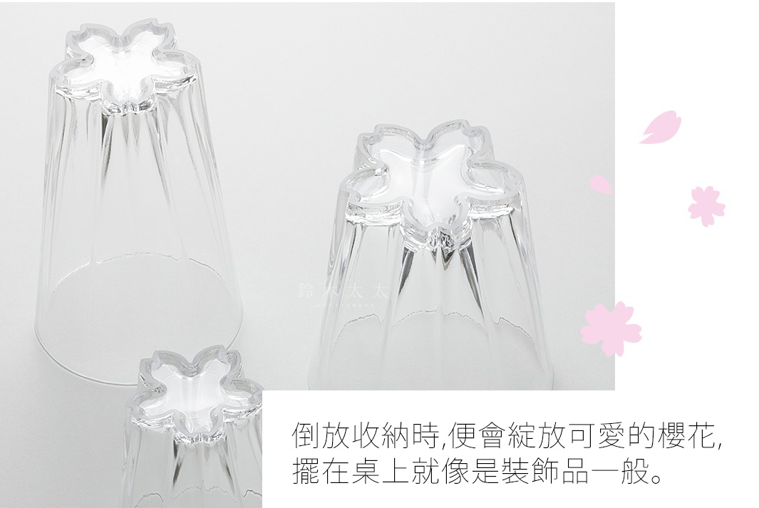 透明壓克力材質的櫻花造型杯，底部設計成五瓣櫻花形狀，杯身有細緻的直條紋路，光線透過時呈現晶瑩剔透感。