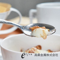 日製不鏽鋼湯匙，表面有錘目紋，盛著白色甜點與焦糖醬。