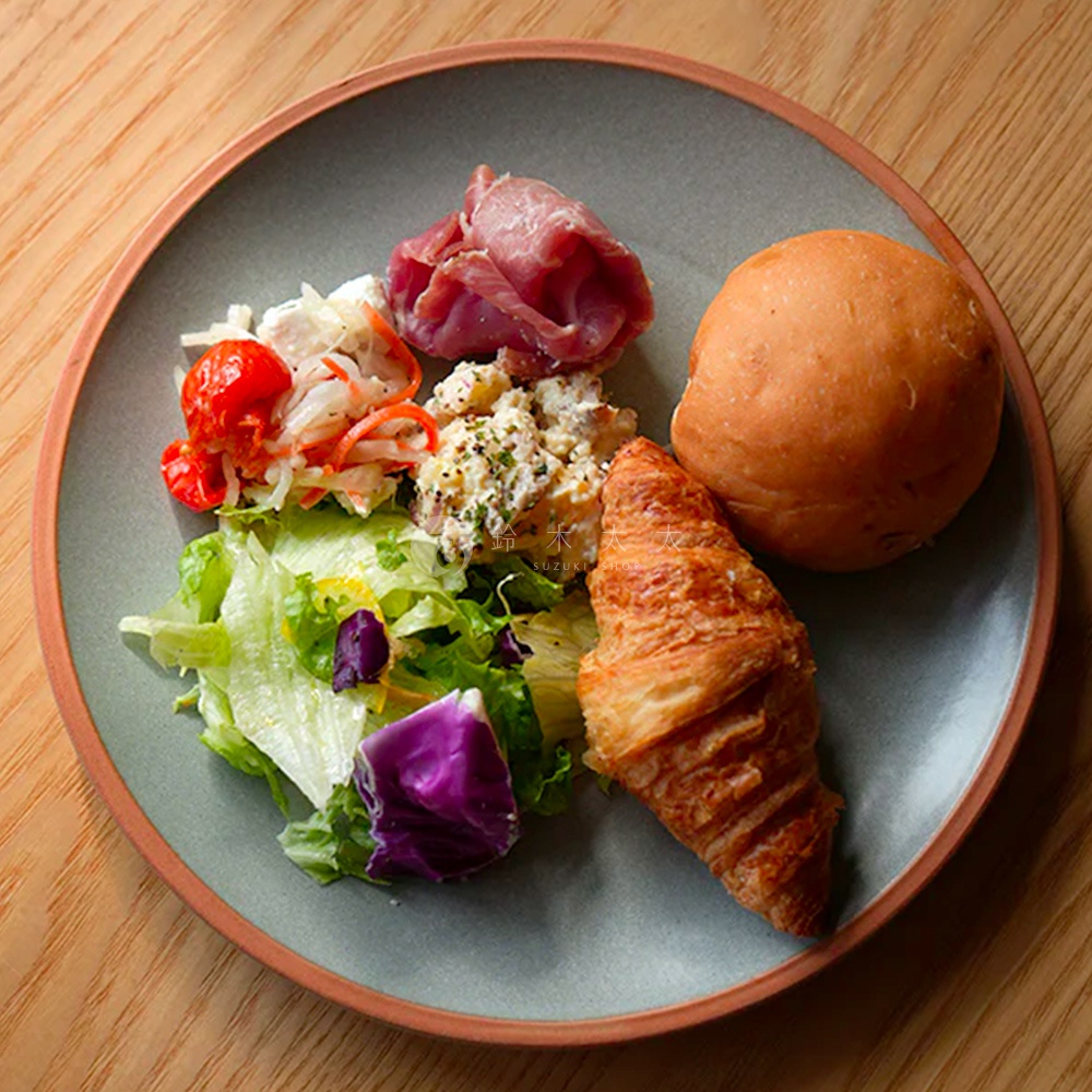 PURE 素燒百搭陶瓷主菜盤 M，灰綠色盤身搭配陶土色盤緣，盛有可頌、麵包、火腿、馬鈴薯沙拉與綜合生菜沙拉。