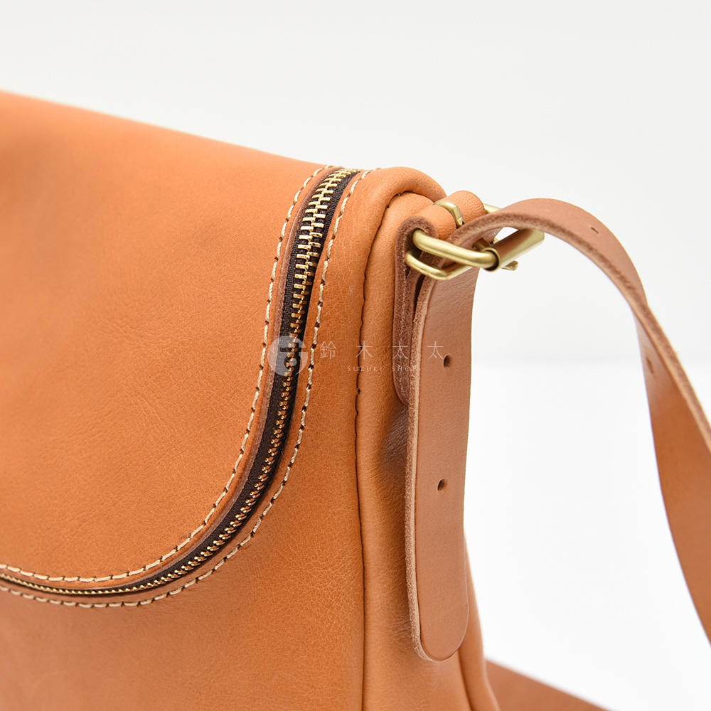 日本HERZ職人手作棕色皮革馬鞍包近拍，展現縫線細節與黃銅金屬扣環