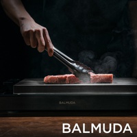 黑色極致電烤盤上，手持夾子翻動著兩塊正在烹調的牛肉，烤盤散發出陣陣蒸汽。