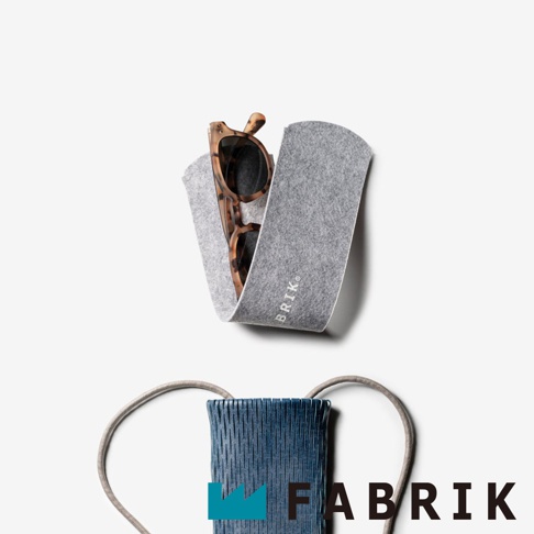 FABRIK 品牌 logo 與一個裝有墨鏡的灰色絨布收納套，下方是一個藍色編織紋理的小包，有灰色背帶。
