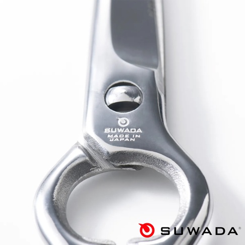 一張特寫視角的 SUWADA 諏訪田製作所多功能廚房剪刀金屬連接處照片，畫面中清晰可見刀具轉軸上的圓形品牌標誌，下方刻有 SUWADA 以及 MADE IN JAPAN 字樣，展示出日本手工金屬剪刀精細的拋光質感與構造細節。