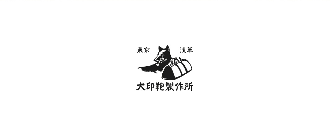 黑色犬印淺草帆布橫式側背包，帶有品牌標誌，上面有狗和包的圖案，以及日文文字「東京」、「淺草」、「犬印鞄製作所」。