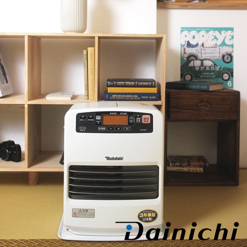 大日Dainichi白色電子式煤油暖氣機，擺放在木製層架旁，上方有書本和裝飾畫，前方有黑色相機。