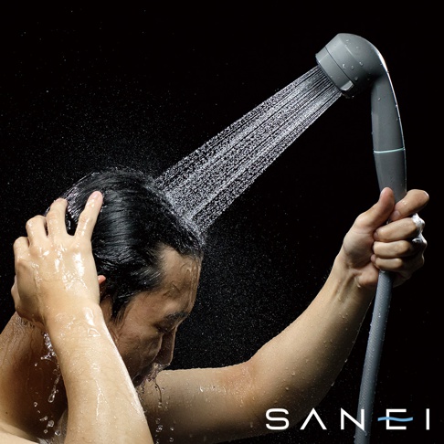 一名男子正在使用灰色兩段式水流專髮按摩蓮蓬頭，噴灑的水流集中且有力量。