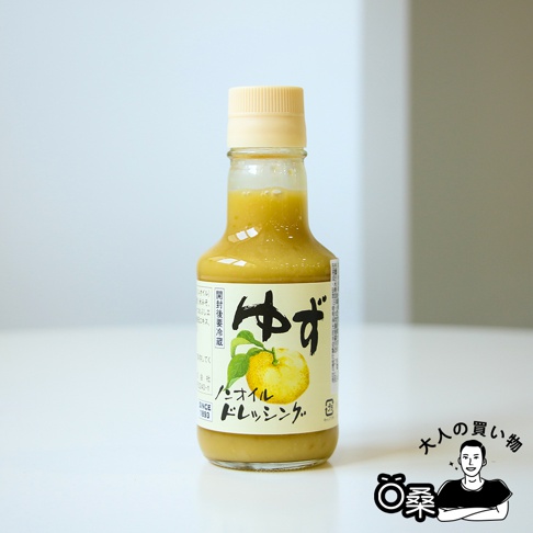 玻璃瓶裝無油柚子風味沙拉醬，醬體呈現黃褐色，瓶蓋為淺黃色。瓶身貼有標籤，標籤上有柚子圖案及日文文字，標示產品名稱和內容。