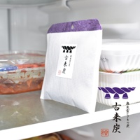 白色布袋裝的古來炭迷你調濕木炭，頂部有紫色紋理的裝飾，袋身印有黑色繩結圖案與中文「古來炭」字樣。