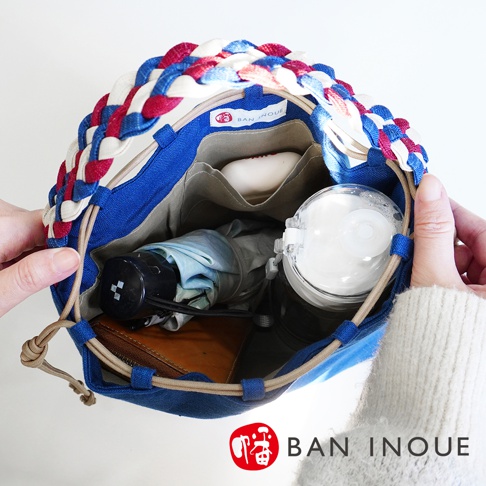 BAN INOUE 品牌標籤的麻花辮束口手提包，內有摺疊傘、水壺和錢包