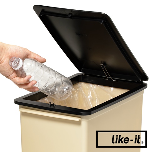 象牙白掀蓋式矮版垃圾桶，內部裝有透明垃圾袋。垃圾桶的掀蓋為黑色，邊緣有黑色框。一隻手正將一個裝有水的透明塑膠瓶投入垃圾桶。