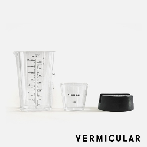 透明量杯、透明米杯，以及一個黑色鑄鐵鍋底座，均帶有 Vermicular 品牌標識。